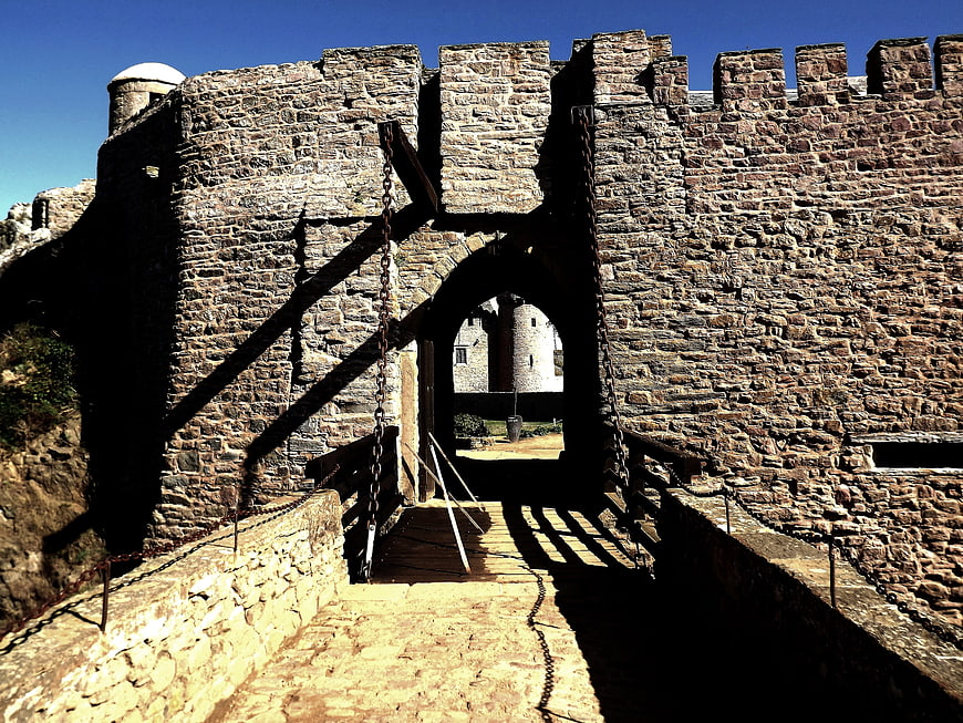 Medieval stone castle gate with drawbridge and chains