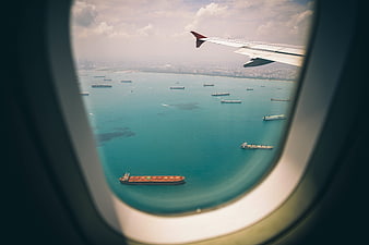 Aerial View of Cargo Ships from Airplane Window
