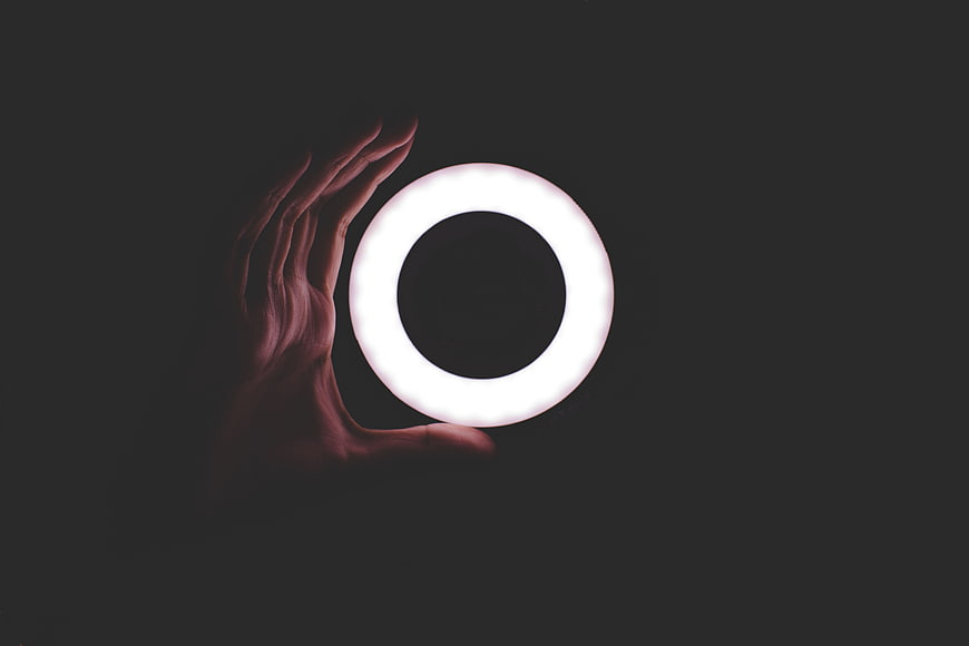 Hand Holding Glowing White Circle Light in Dark Space