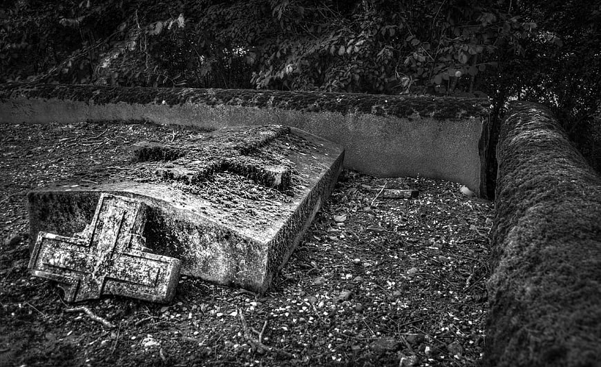 Broken Tombstone in Overgrown Cemetery at Night
