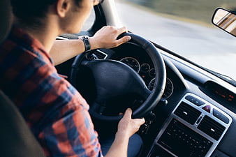 Man Driving Car on Road with Hands on Steering Wheel