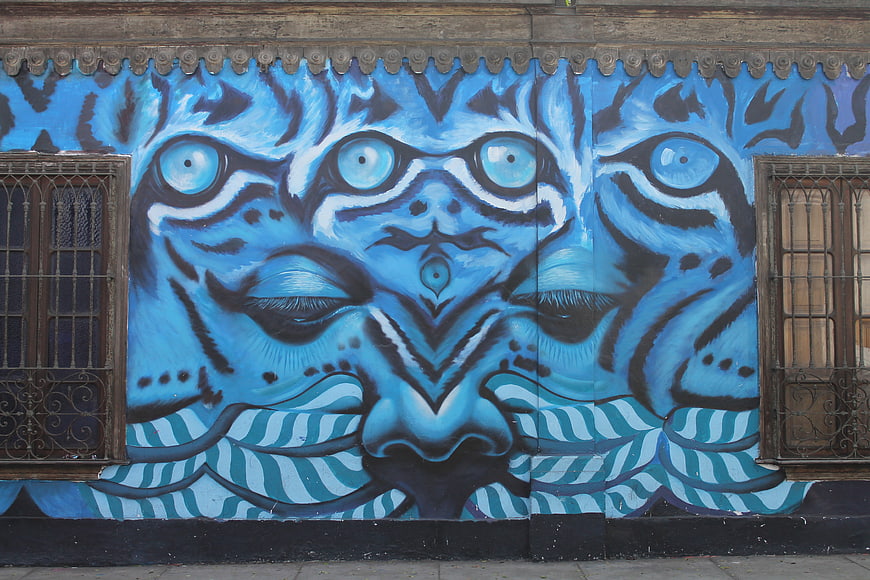 Blue Surreal Street Art Mural with Multiple Eyes and Face