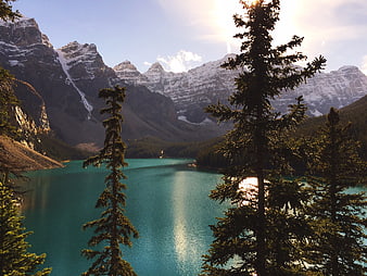 Turquoise Mountain Lake with Pine Trees and Snowy Peaks