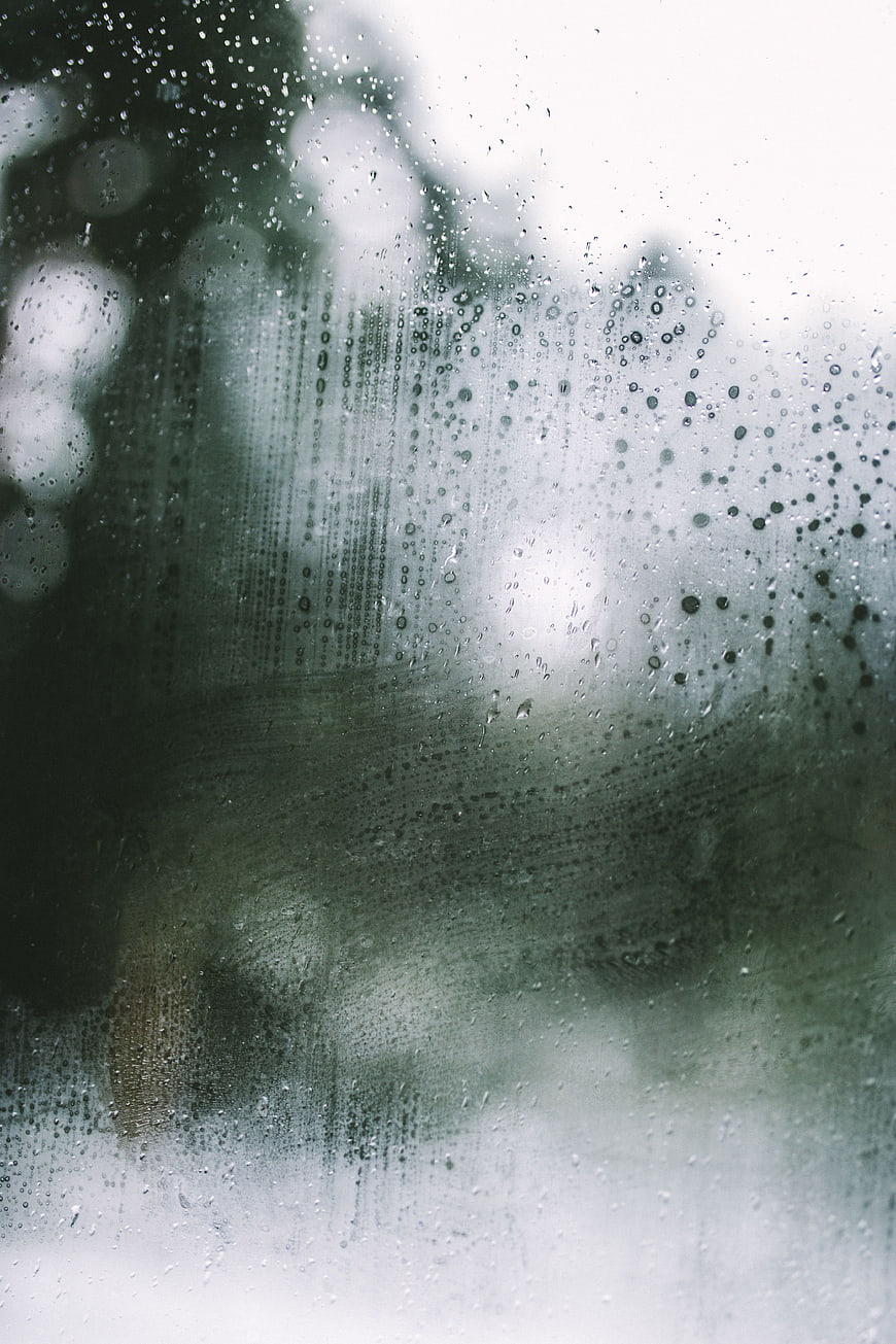 Raindrops on a foggy window with blurred background