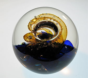 Abstract glass paperweight with amber and blue swirls