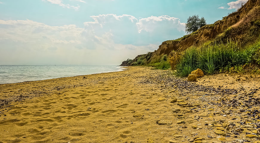Sandy Beach Shoreline with Cliffs and Ocean Horizon