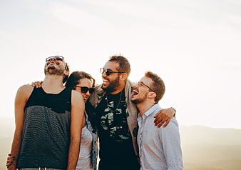 Happy Friends Laughing Together Outdoors at Sunset