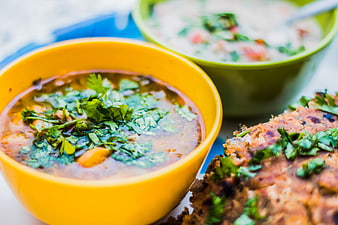 Yellow bowl of Indian dal soup with paratha bread