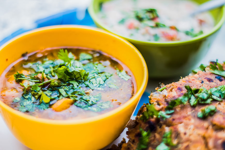 Yellow bowl of Indian dal soup with paratha bread