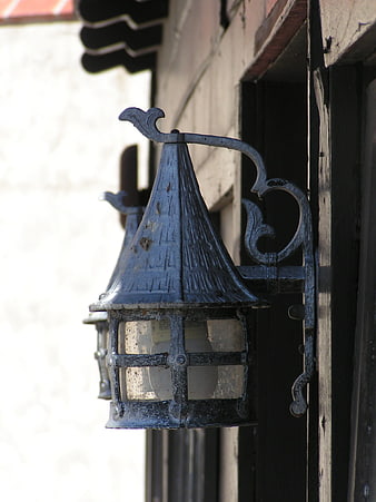 Vintage black lantern on rustic wooden building exterior