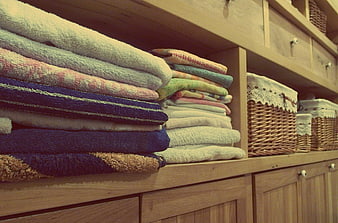 Stacked Colorful Towels in Wooden Linen Cabinet