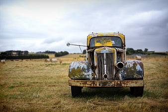 Rusty vintage yellow truck in a dry field