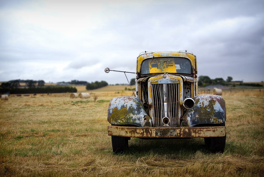 Rusty vintage yellow truck in a dry field