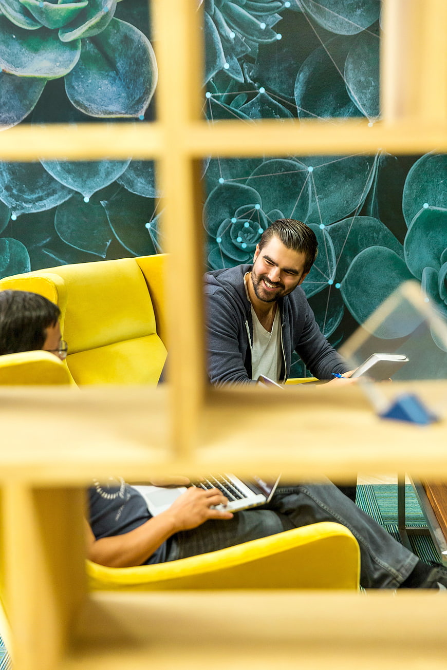 Smiling man working on laptop in modern office