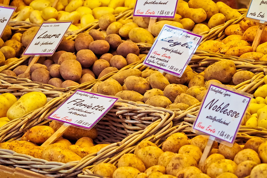 Fresh Potatoes In Wicker Baskets At Farmers Market