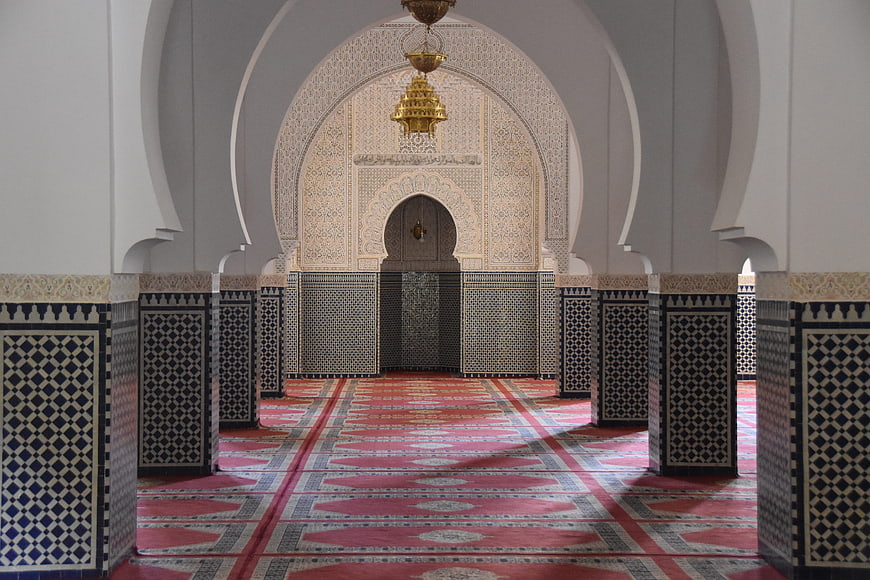 Interior of a Moroccan Mosque with Intricate Archway and Patterned Carpet