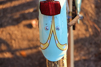 Close-up of vintage blue bicycle fender with red reflector