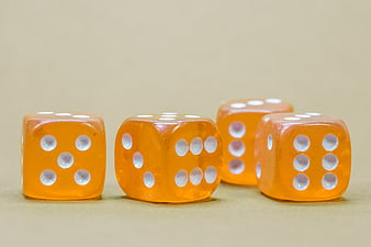 Four Orange Dice Showing High Numbers on Beige Background