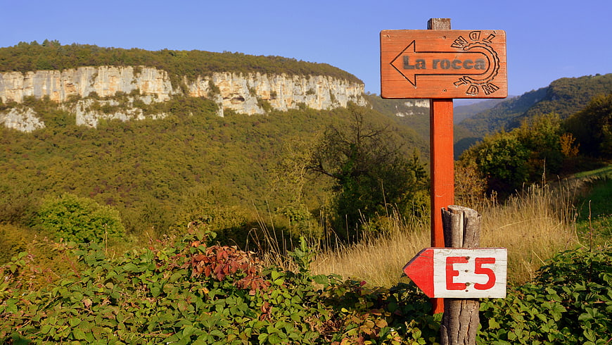 Wooden hiking trail signpost in Italian mountain landscape