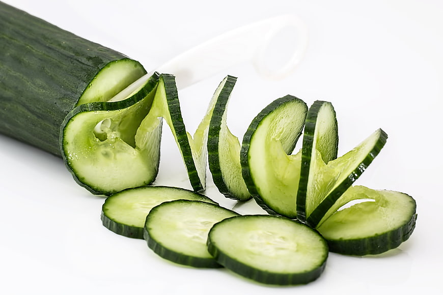 Fresh Cucumber Slices and Spiral Peel on White Background