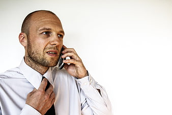 Bald Businessman Talking On Mobile Phone Adjusting Black Tie