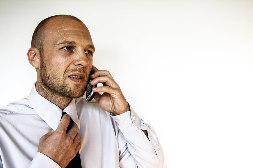 Bald Businessman Talking On Mobile Phone Adjusting Black Tie