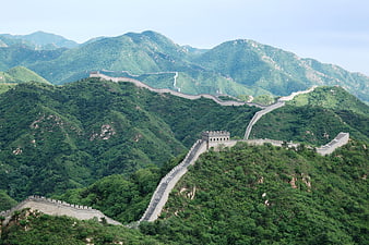 Great Wall of China winding through green mountains