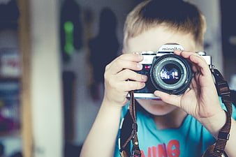 Young boy holding vintage Minolta film camera