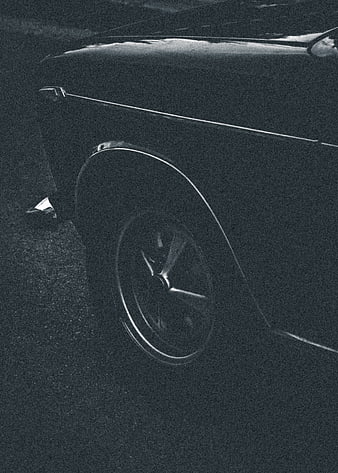 Vintage black car wheel detail in grainy monochrome