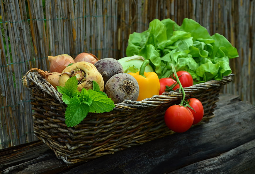 Fresh organic vegetables in a rustic wicker basket