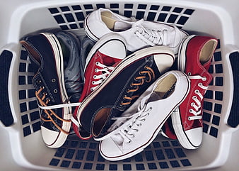 Assorted Unpaired Sneakers in White Laundry Basket