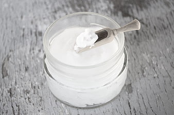 Coconut Oil In Glass Jar With Wooden Spoon On Rustic Wood