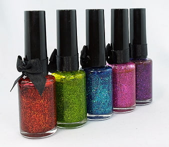Five Glitter Nail Polish Bottles With Black Caps And Ribbons