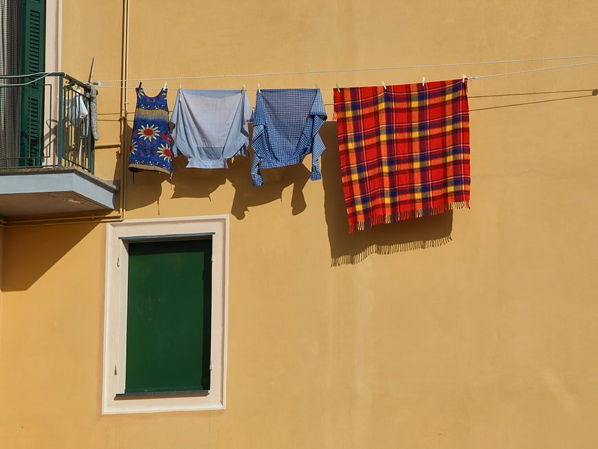Colorful Laundry Hanging on Yellow Building Wall