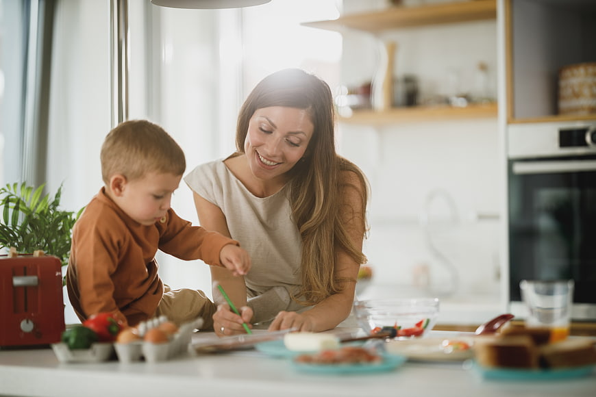 Mother and son cooking breakfast together in kitchen