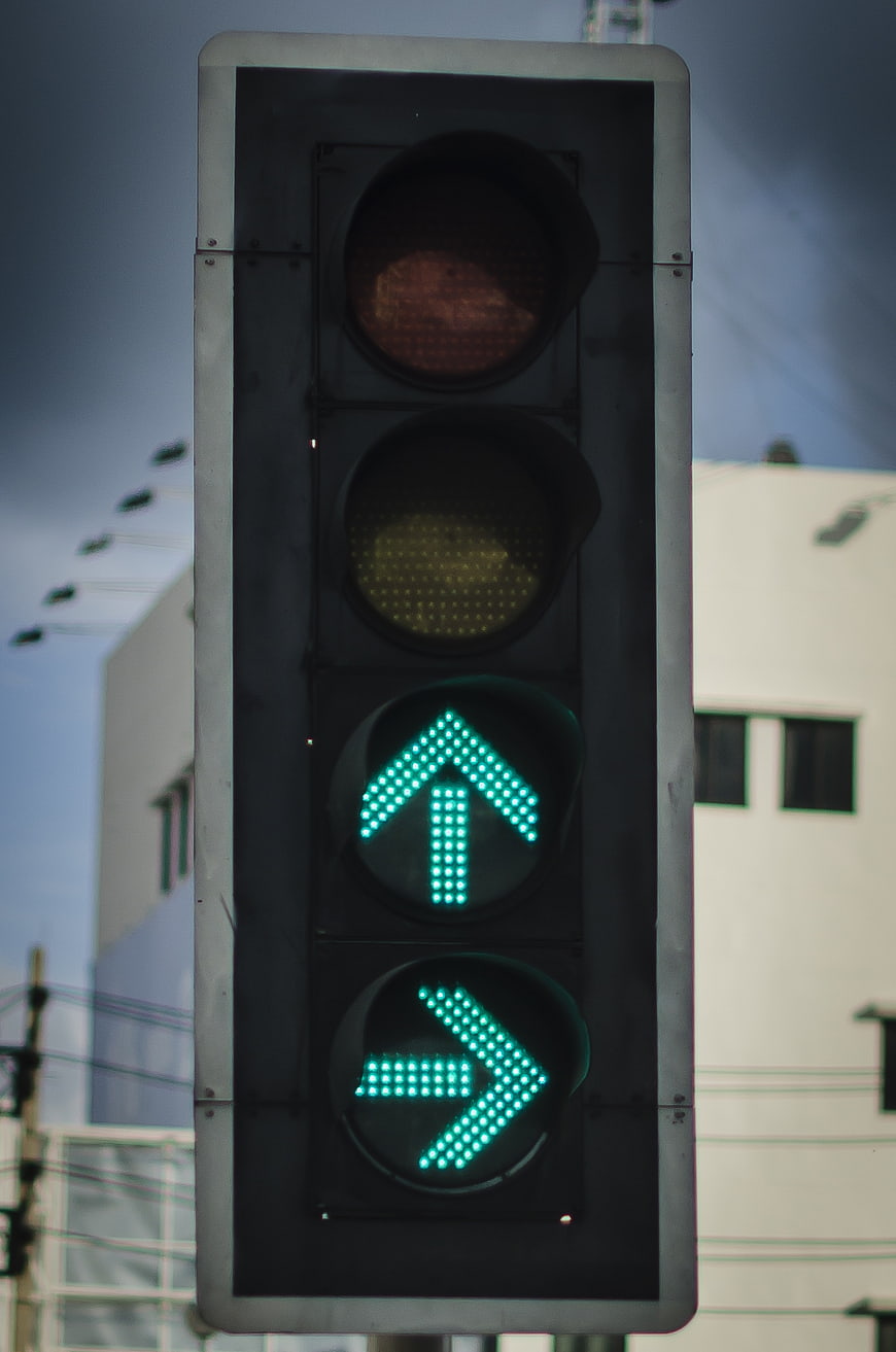 Close-up of traffic light with green straight and right arrows
