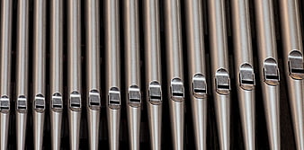 Close-up of silver metal organ pipes with fipple mouths