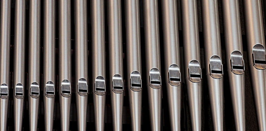 Close-up of silver metal organ pipes with fipple mouths