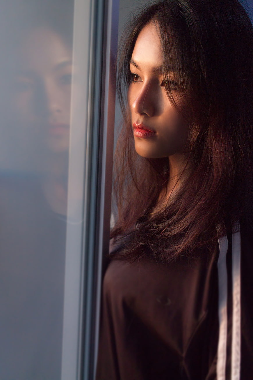 Cinematic Portrait of Young Woman Looking Out Window
