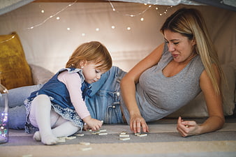 Mother and Toddler Playing Dominoes in Cozy Indoor Fort