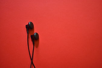 Black Earphones on Vibrant Red Background with Copyspace