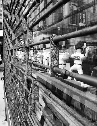 Black and white baseball figurines behind metal security bars