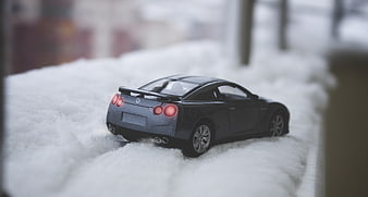 Gray toy sports car model in snow