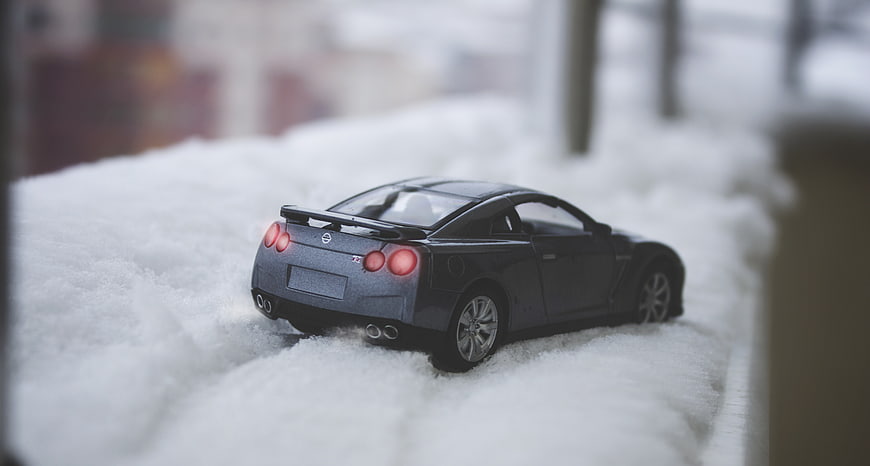 Gray toy sports car model in snow