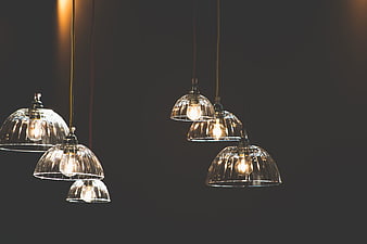 Modern glass pendant lights hanging against dark background