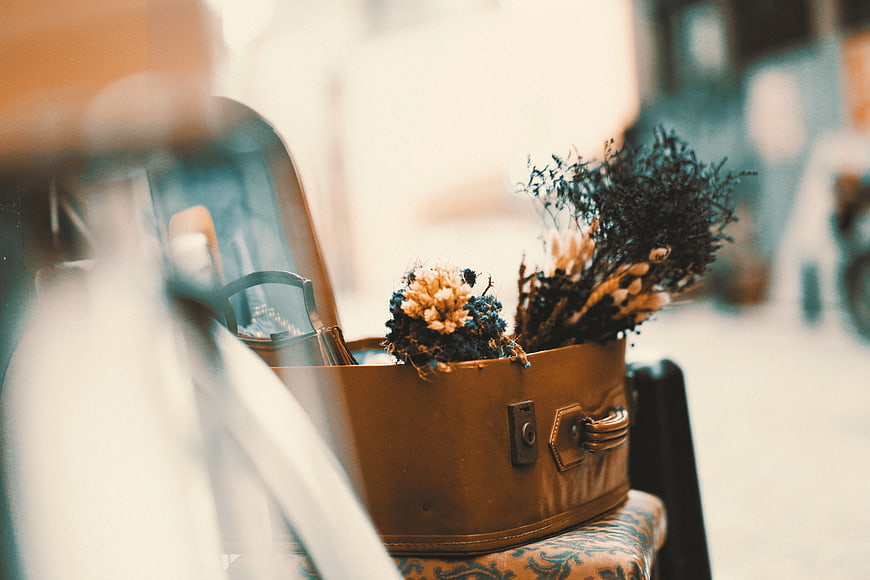 Vintage suitcase with dried flowers on a chair