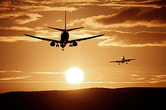 Two Airplanes Landing at Golden Sunset