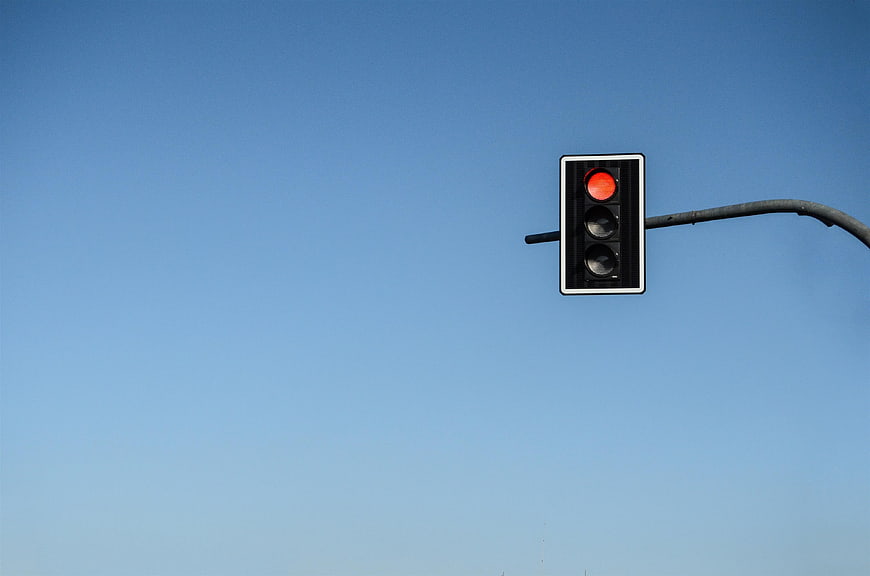 Red Traffic Light Against Clear Blue Sky