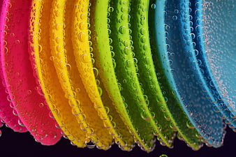 Close-up of colorful plastic cups with water droplets