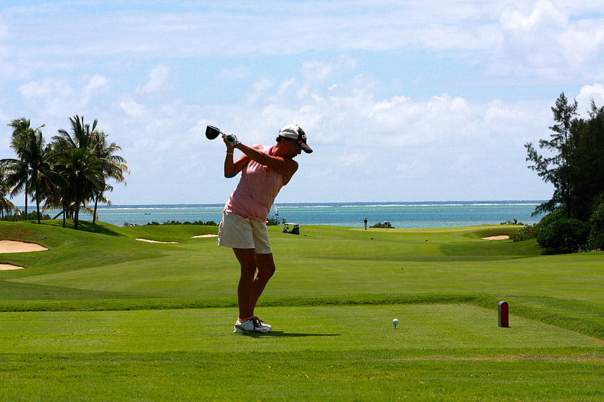 Woman Golfing on Tropical Course with Ocean View